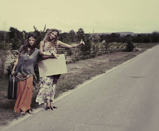 2 hitchiking 大会の女性 - 1970s style hippie couple retro revival ストックフォトと画像
