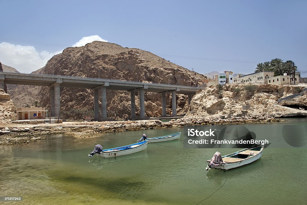 Wadi "Highway viaduct and motor boats at the entrance of Wadi Al Shab, Oman." Wadi Shab Stock Photo