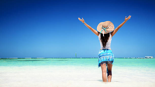 Carefree young woman relaxing on tropical beach stock photo