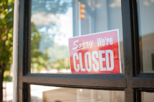 Sorry, We're Closed Sign in a small town main street  storefront window.