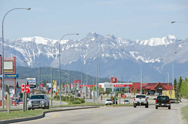 Hinton and Yellowhead Highway "Edson, Canada - May 27, 2012:  In the town of Hinton the main road and highway through the town  with retail shops and service buildings. The Rocky Mountains are in the distance.  Hinton is on the Yellowhead Highway between Jasper and Edmonton." hinton alberta stock pictures, royalty-free photos & images