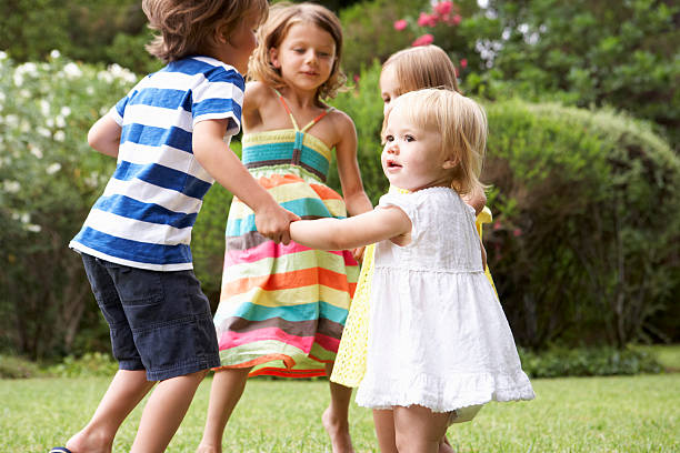 groupe d'enfants jouant à l'extérieur ensemble - toddler child nature friendship photos et images de collection