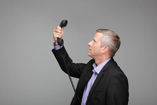 Business man holds telephone
