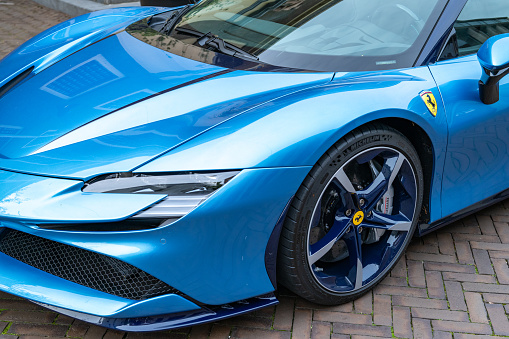 Close-up Of Red And Blue Car In Front Of Businessman Writing On Paper