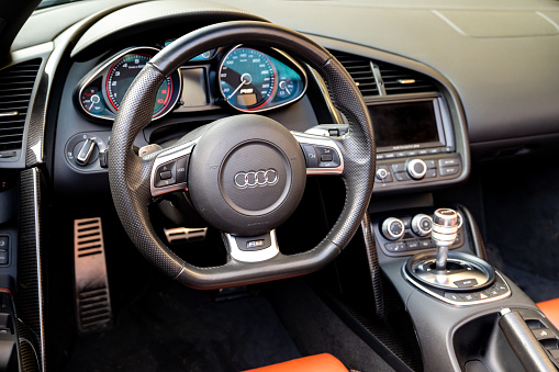 Audi R8 sports car dashboard. The Audi R8 is a mid-engine, two-seater sports car manufactured and marketed by the German automobile manufacturer Audi. The Audi R8 V10 Plus is a high-performance variant of the Audi R8 sports car.