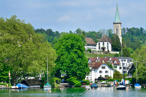 Zurich, Switzerland - May 25, 2023: Beautiful houses and church in Lake Zurich.