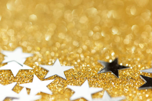 Golden star confetti on a dark backdrop creates a festive, luxurious, and sparkling celebration vibe.
