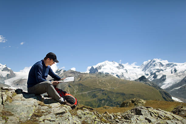 istock Hiker sitting in the mountains reviewing a map 171318501