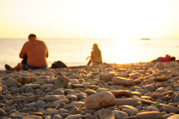 Russia, Lazarevskoye, Krasnodar Territory, September 2023. Sunset with people on the seashore. Beautiful landscape.