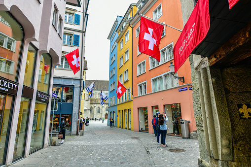 Zurich - May 15 ,2023 :Swiss flags and colorful houses in Strehlgasse streets of old Zurich, Switzerland
