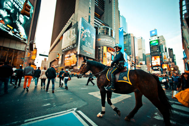 New York City, USA - July 9, 2016: Black Lives Matter protestors march down a street in Times Square in New York City, demonstrating against police violence. One man marches with arms outstetched, a crucifix in one hand.