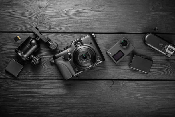 istock Digital compact and action cameras and equipment on black wooden plank table. top view. 1713194314