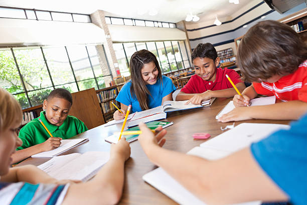 istock Diverse group of students studying together in library 171319529