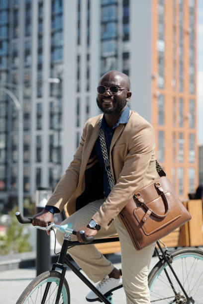 istock Happy young successful man in quiet luxury attire sitting on bicycle 1713199974