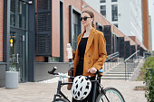 Young modern female entrepreneur with bottle of water and bicycle