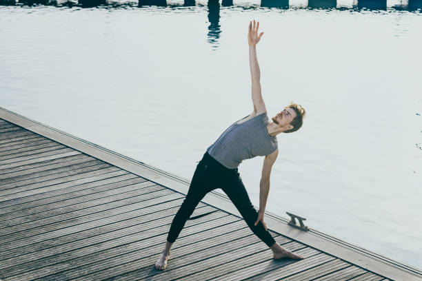 istock Young red-haired male athlete performing stretching after training to gain flexibility and relax his muscles, outdoors with unfocused background. 1713202805