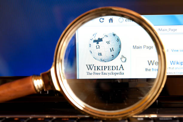 Wikipedia website through a magnifying glass stock photo