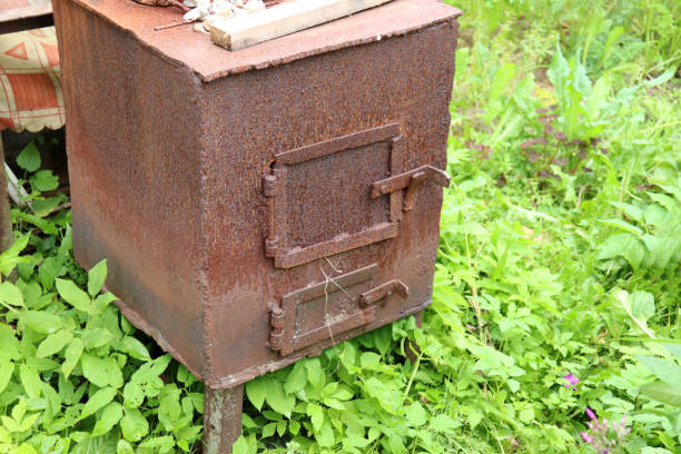 An old homemade cast iron stove in the courtyard of a village house. Horizontal photo, close-up