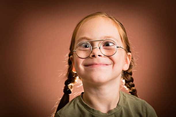 маленькая девочка в очки и решений nerdy дурачусь лицо - child cross eyed nerd eyewear стоковые фото и изображения