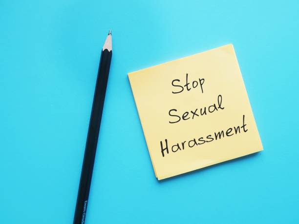 Pencil wrote on office notepad on blue background with handwritten text STOP SEXUAL HARASSMENT, to stop unwanted persistent attacks behaviour which makes employee feel intimidated or offended, causes emotional or mental suffering in workplace lápiz escrito en el bloc de notas de la oficina sobre fondo azul con texto escrito a mano stop sexual harassment, para detener el comportamiento de ataques persistentes no deseados que hace que el empleado se sienta intimidado u ofendido, causa sufrimient