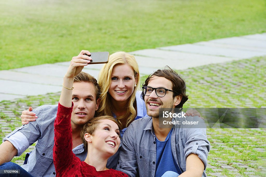 Czterech przyjaciół zabawa na piknik z kamery - Zbiór zdjęć royalty-free (Aparat fotograficzny)