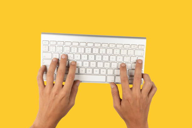 istock Office desk table Top view with keyboard and hand yellow background 1713219973