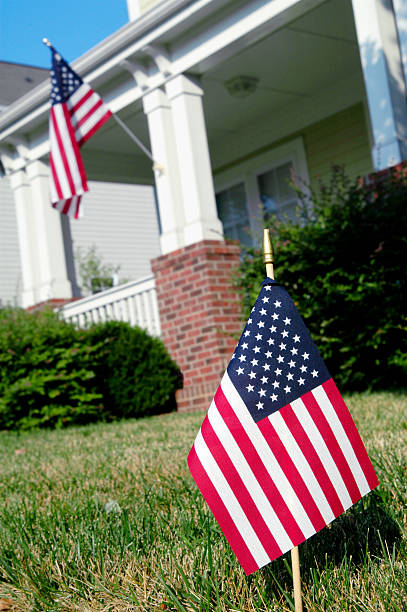 istock two American flags in front yard of bungalow style house 171322031