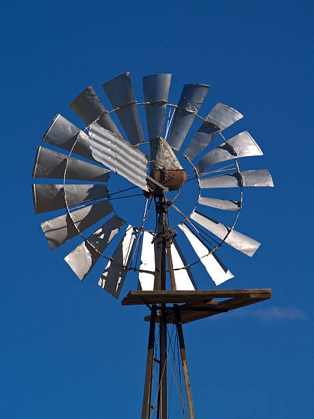 Windmill against blue sky stock photo
