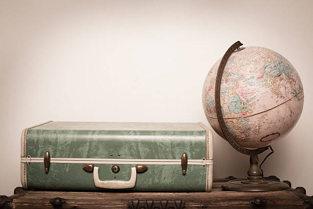 Retro Green Suitcase, Sitting on Wood, With Globe "Color image of an old, retro, green suitcase, sitting on wood trunk, with a globe. Includes copy space." desktop globe stock pictures, royalty-free photos & images