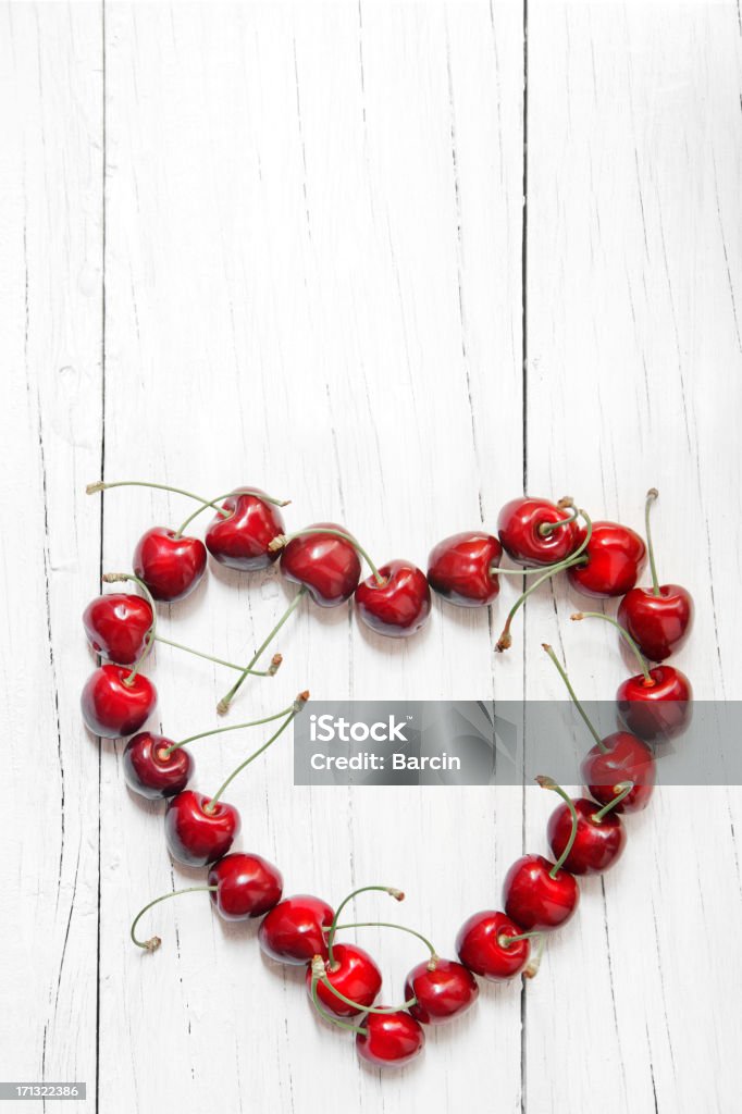 Heart shaped cherries Fresh red heart shaped cherries on wooden background Berry Fruit Stock Photo