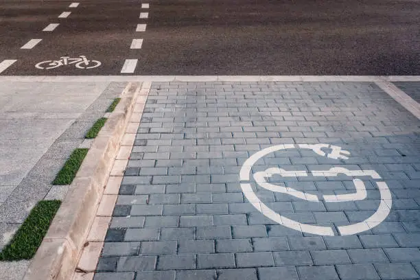 New bike lanes next to recharging stations for electric vehicles on paved asphalt.