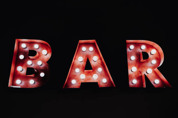 istock Bar written with luminous bulbs on a dark black background. 1713227818