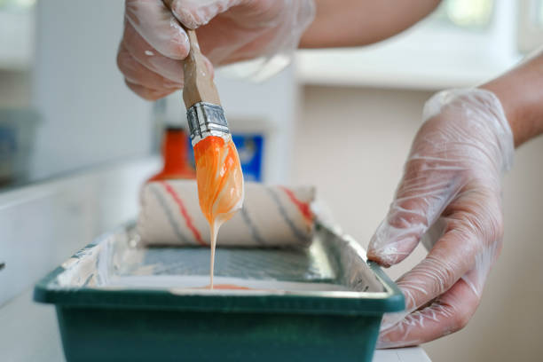 istock painter mixes paint in a tray before painting the walls 1713232131