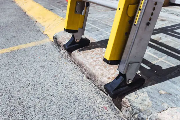 A portable ladder resting on the ground during electrical wiring repairs.