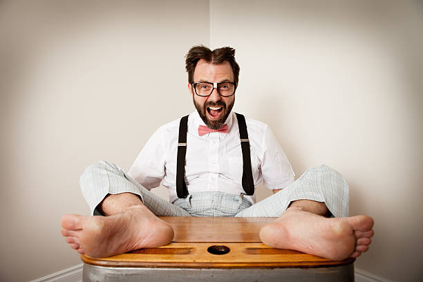 nerd excité garçon assis avec les pieds sur old school bureau - desk men bizarre classroom photos et images de collection
