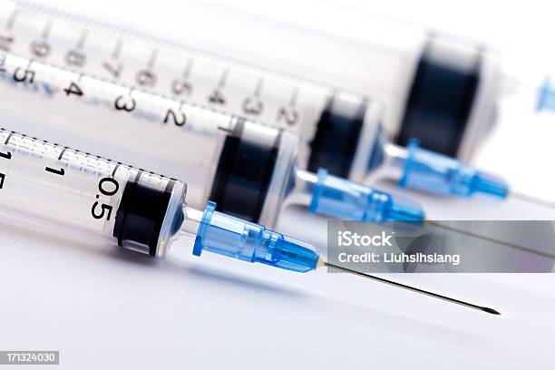Row Of Medical Syringes With Blue Lids Stock Photo - Download Image Now - Syringe, Injecting, Healthcare And Medicine