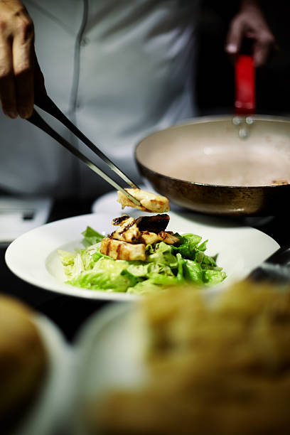 Chef preparing dishes for dinner.Caesar's salad with grilled chicken
