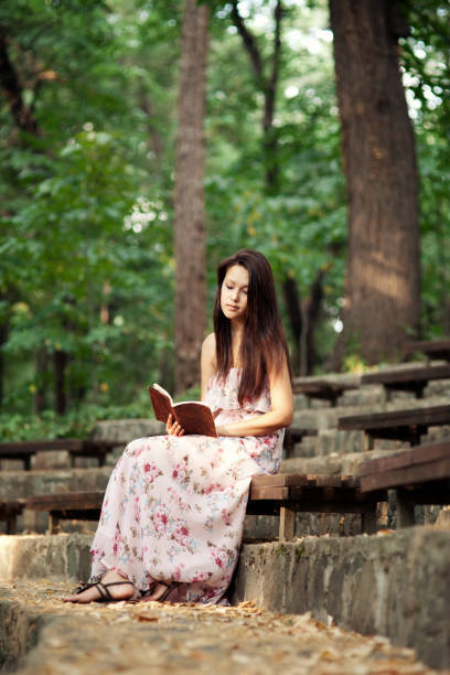 beautiful girl reading a book on street stairs