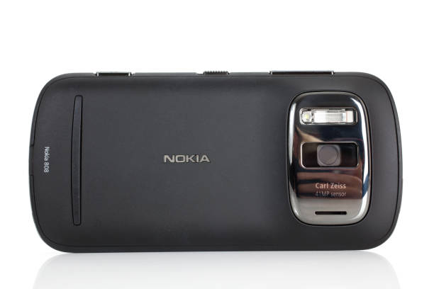 Nokia Pureview 808 Mobile Phone "Hertfordshire, UK - August 6, 2012: Back of a Nokia Pureview 808 Mobile Phone standing on white surface with its 41 megapixel camera sensor in view. Studio shot on white background." phone nokia stock pictures, royalty-free photos & images