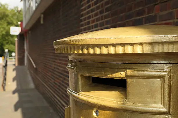 Photo of commemorative gold painted olympic post box in harlow essex england
