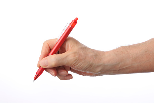 Writing with the red ball point pen isolated on white background.