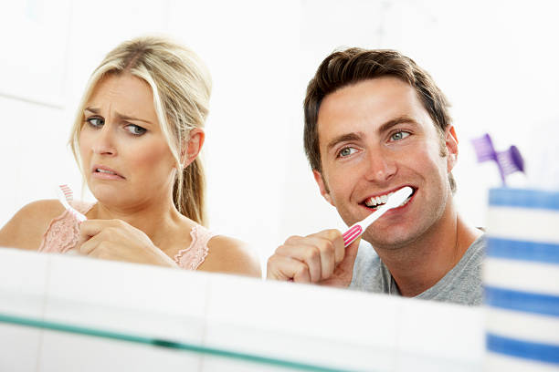 пара, чистить зубы в ванной комнате - brushing teeth healthcare and medicine cleaning distraught стоковые фото и изображения