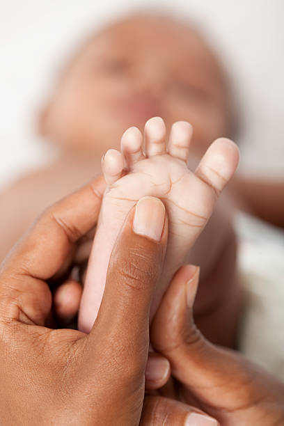 bebé massagem nos pés. - newborn human hand baby father imagens e fotografias de stock