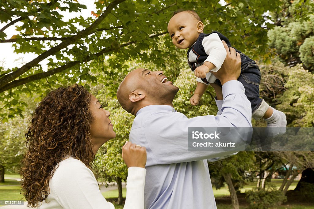 Mãe e pai brincando com seu bebê menino no parque - Foto de stock de 25-30 Anos royalty-free