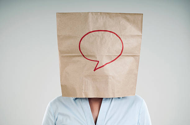 paper bag businesswoman wearing a paper bag with blank speech bubble embarrassment unrecognizable person wearing a paper bag human head stock pictures, royalty-free photos & images