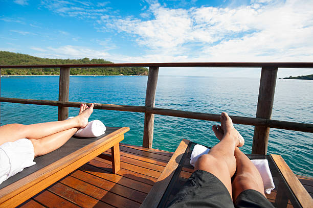 pareja en el balcón del bungalow sobre el agua, - horizon over water england uk summer fotografías e imágenes de stock