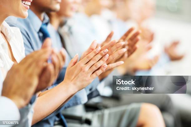 Group Of Businesspeople Sitting In A Line And Applauding Stock Photo - Download Image Now