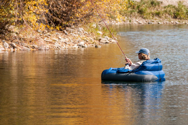 donna pesca a mosca da un tubo galleggiante - individual event women people autumn foto e immagini stock