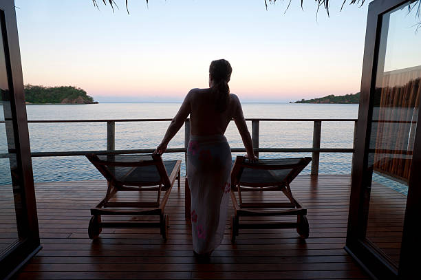 Woman watching the sunset in an over water bungalow