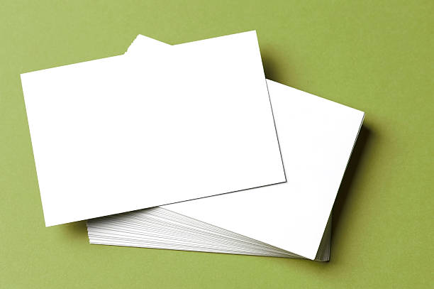 Pile of blank white cards on a green surface/background